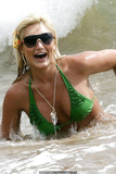 Brooke Hogan in green bikini on a beach