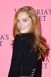 Redhead Alexina Graham in short black dress shows her long sexy legs