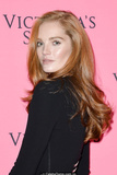 Redhead Alexina Graham in short black dress shows her long sexy legs