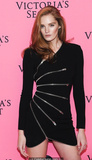 Redhead Alexina Graham in short black dress shows her long sexy legs